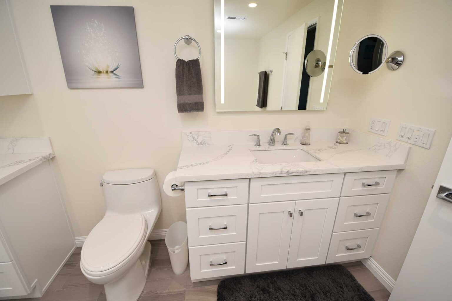 Bathroom vanity with two sinks, a stone top and drawers either side.