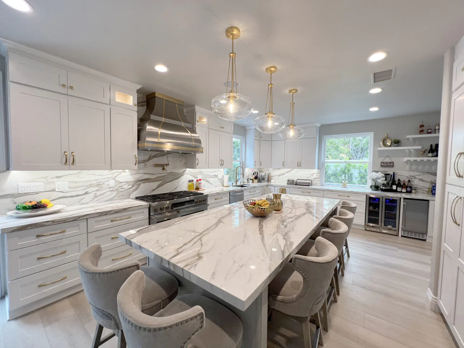 Remodeled Orange County kitchen with a marble waterfall island and pendant lighting