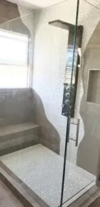 Shower interior with a multi function panel column and a mosaic tile floor