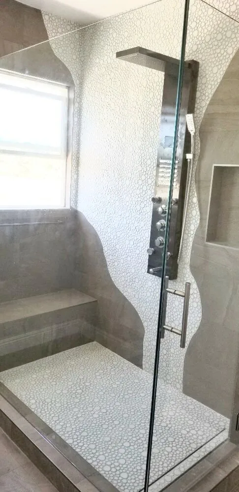 Shower interior with a multi function panel column and a mosaic tile floor