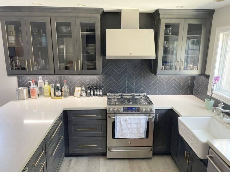Navy base cabinets with deep drawers and brass pulls, under glass fronted upper cabinets.